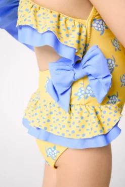 Bañador niña detalles volantes y lazos estampado tortugas amarillo