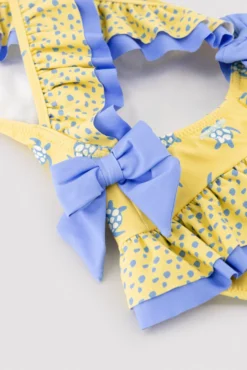 Bañador niña detalles volantes y lazos estampado tortugas amarillo