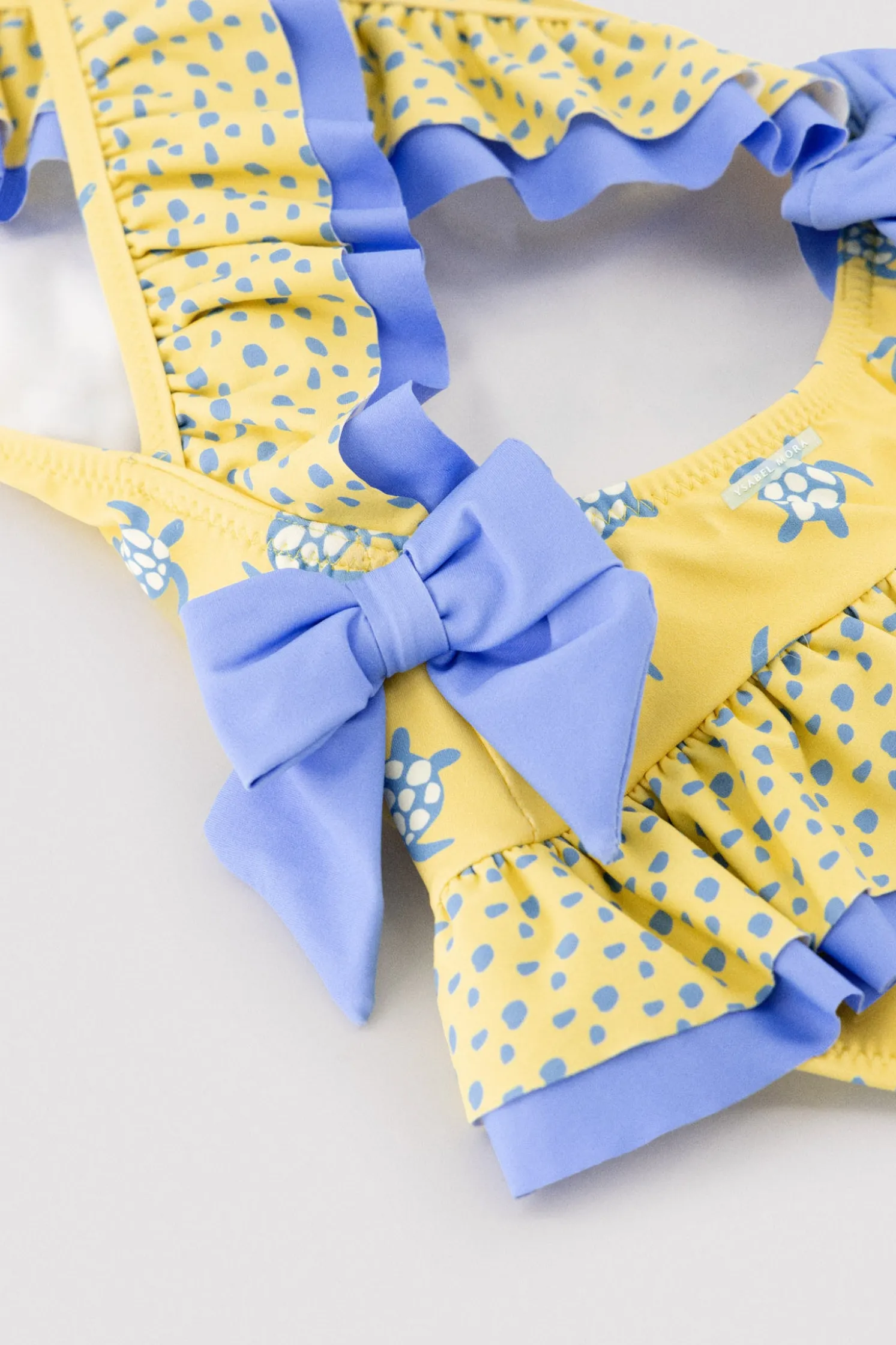 Bañador niña detalles volantes y lazos estampado tortugas amarillo