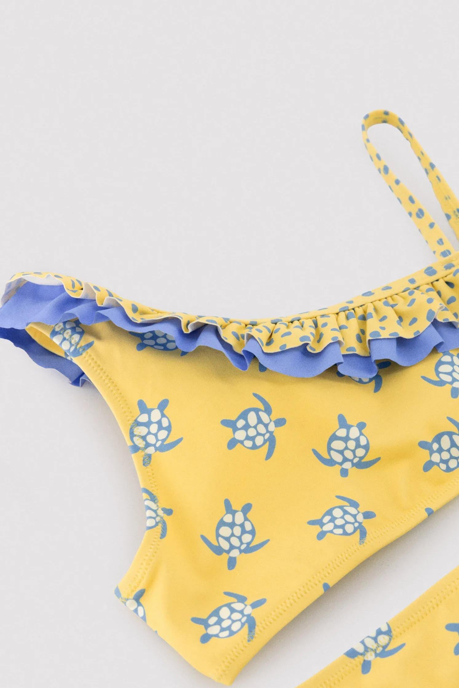 Bikini niña asimétrico detalle volantes estampado tortugas amarillo
