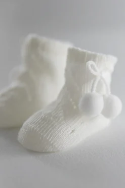 Calcetines perlé con borlas recién nacido marfil